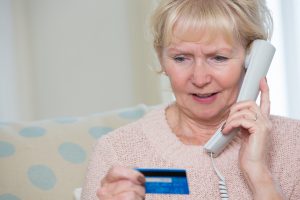 Senior Woman Giving Credit Card Details On The Phone