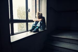 Depressed little boy in old staircase