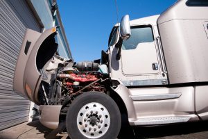 semi truck with its hood up after being in a crash