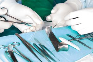 surgeon cuts mesh for hernia