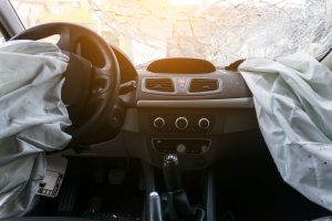 damaged car dashboard with deployed air bags