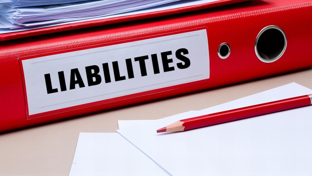 How to File a Truck Accident Claim in Oklahoma 2 Red binder labeled liabilities on a desk with papers and pencil, symbolizing legal responsibility after an accident