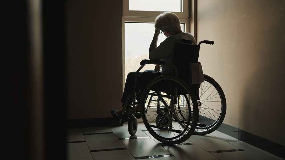 Can You Sue for Loss of Enjoyment of Life in Oklahoma?: Answers and Next Steps for Your Case 1 Elderly woman in a wheelchair sitting near a window with her hand resting on her forehead