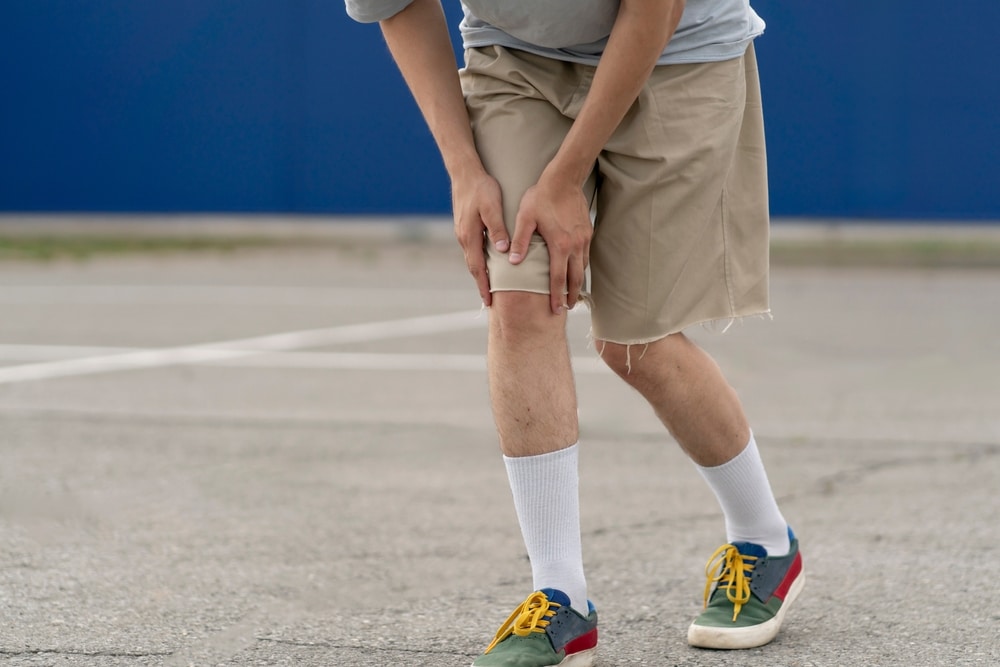 Oklahoma City Premises Liability Lawyer 4 Person holding their knee after a fall, illustrating common premises liability injuries