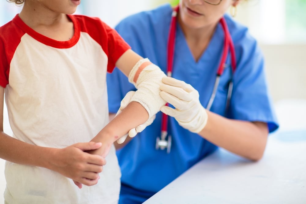 Medical professional treating a child’s arm injury during pediatric care