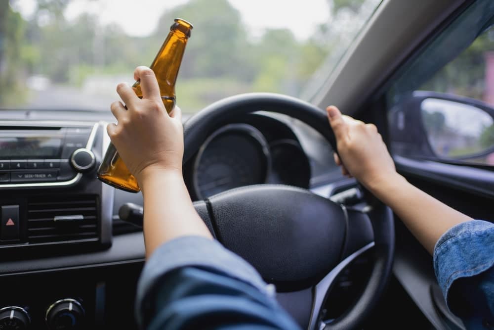 Tulsa Drunk Driving Accident Lawyer 2 Drunk driver holding an alcoholic beverage while driving, illustrating impaired driving risks