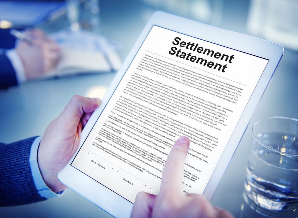Person reviewing an insurance settlement offer document on a tablet before accepting compensation