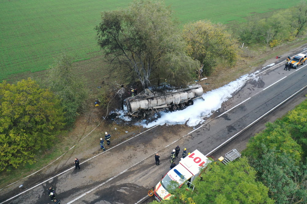 Aerial view of an overturned truck accident scene with emergency responders on a rural road